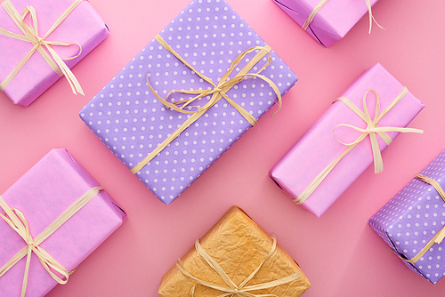 top view of colorful and wrapped gift boxes on pink