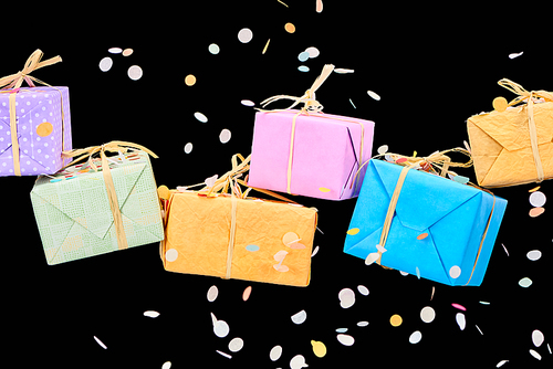 falling confetti near colorful gift boxes on black