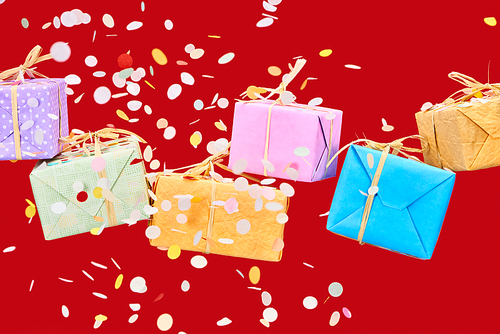 falling confetti near colorful gifts on red