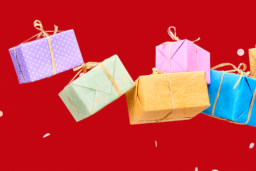 confetti near colorful gift boxes on red