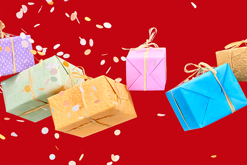 falling confetti near colorful gift boxes on red