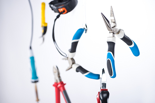 Selective focus of pliers and tools levitating in air isolated on grey