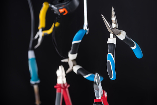 Selective focus of pliers and tools levitating in air isolated on black
