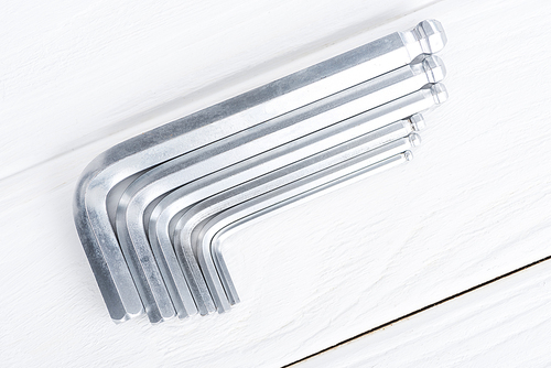 Top view of hex keys on white wooden background