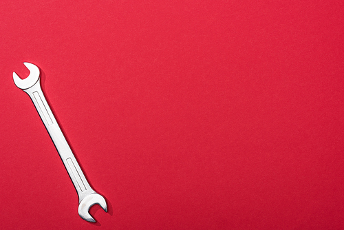 Top view of wrench on red background with copy space