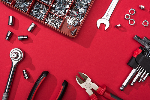 Frame of tool set with wrenches and hex keys on red background