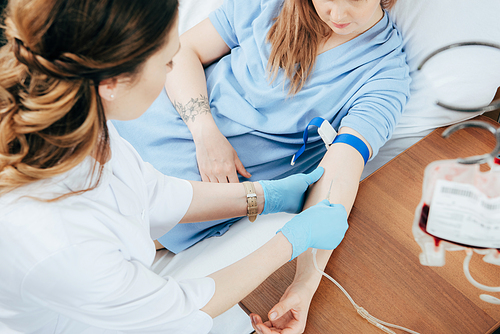 cropped view of doctor in latex gloves doing injection in hospital