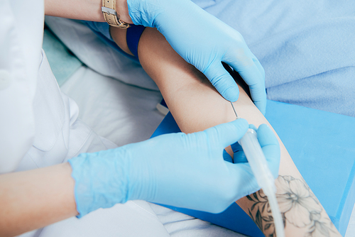 cropped view of doctor in latex gloves doing injection in hospital