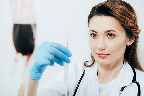 doctor in white coat and latex glove holding syringe in hospital