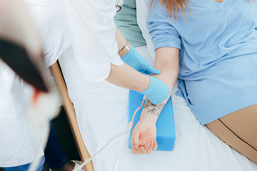 cropped view of doctor in latex gloves doing injection in hospital