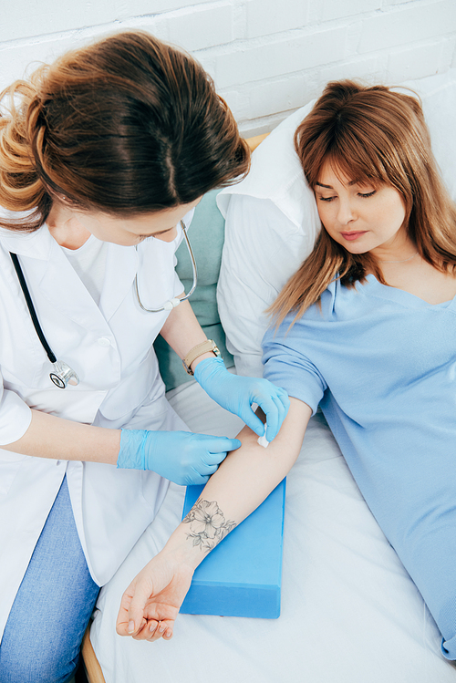 doctor in latex gloves preparing donor for blood donation