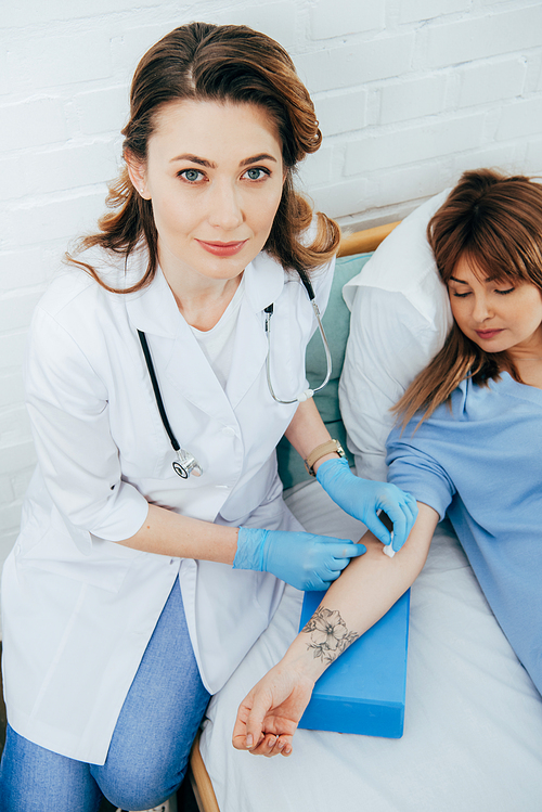 doctor in latex gloves preparing donor for blood donation