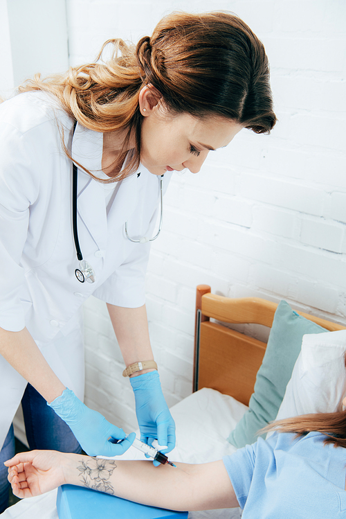 cropped view of donor and doctor with syringe obtaining blood sample