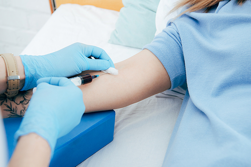 cropped view of donor and doctor with syringe obtaining blood sample