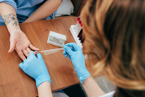 cropped view of donor and doctor obtaining blood sample