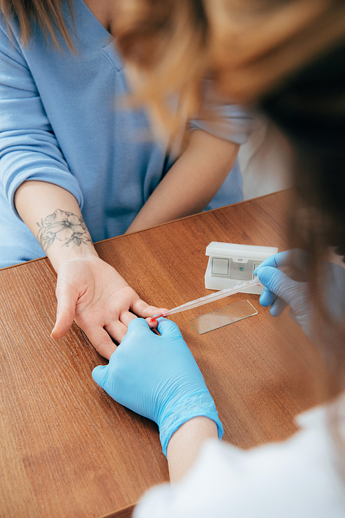 cropped view of donor and doctor obtaining blood sample