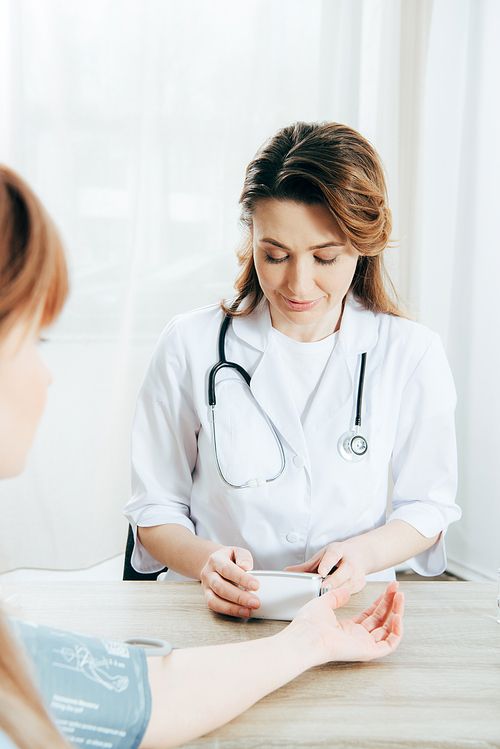 cropped view of patient and doctor measuring blood pressure