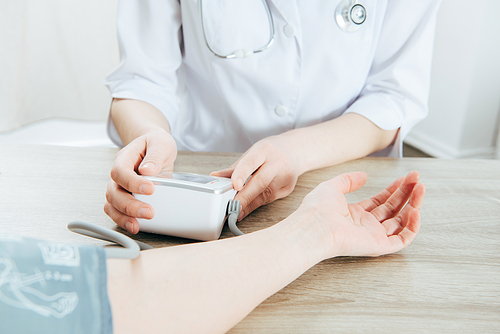 cropped view of patient and doctor measuring blood pressure