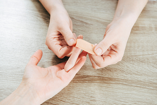 partial view of donor and doctor using adhesive bandage