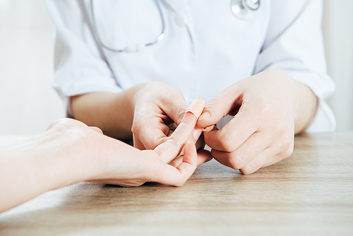 partial view of donor and doctor using adhesive bandage