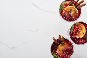 top view of christmas cocktails with orange, pomegranate, cinnamon