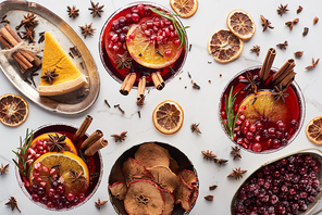 top view of christmas cocktails with orange, pomegranate, cinnamon, pie on tray, dry apples and frozen cranberry