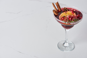 christmas cocktail with orange, pomegranate, cinnamon on marble table