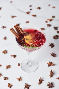 selective focus of christmas cocktail with orange, pomegranate and cinnamon