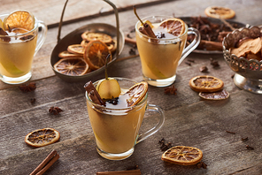 seasonal traditional pear mulled wine with spices in glasses on wooden rustic table