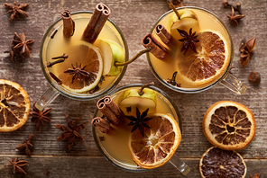 top view of seasonal pear mulled wine cocktails with spices and dried citrus on wooden rustic table