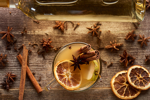 top view of seasonal pear mulled wine cocktail with spices and dried citrus on wooden rustic table