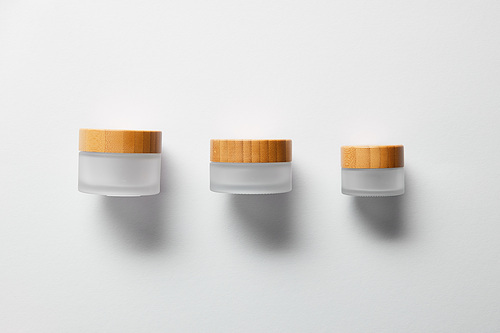three empty jars for hand cream on white