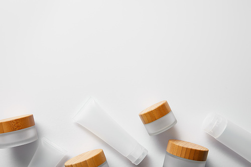 top view of few empty jars and cream tubes on white