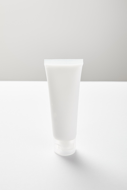 cream tube with hand cream on white