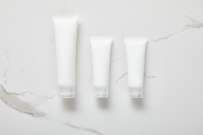 top view of cosmetic cream tubes on white surface