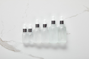 top view of cosmetic glass bottles on white surface