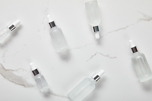 top view of cosmetic glass bottles on white surface