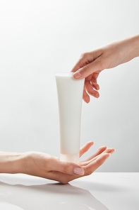 cropped view of woman hands holding cosmetic cream in tube