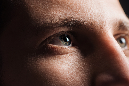 close up view of adult man looking away in darkness