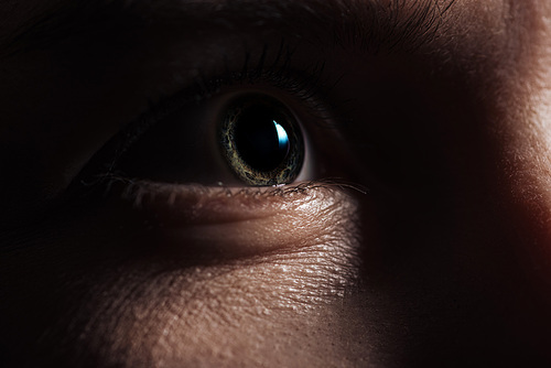 close up view of adult man eye looking away in darkness