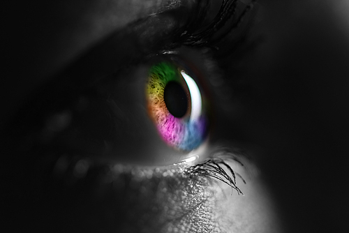 black and white shot of human with bright rainbow colors eye