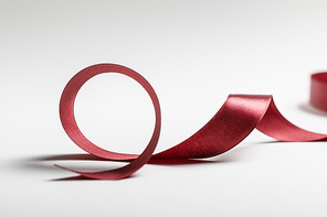 silk curved burgundy ribbon on grey background