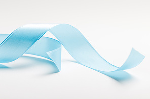 close up of curved blue ribbon on grey background