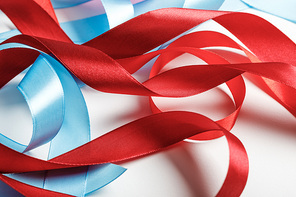 curved blue and red satin ribbons on grey background