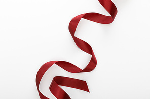 top view of satin burgundy decorative curved ribbon isolated on white