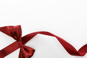 top view of satin burgundy decorative curved ribbon with bow isolated on white