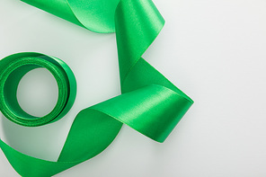 top view of satin green decorative curved ribbon on white