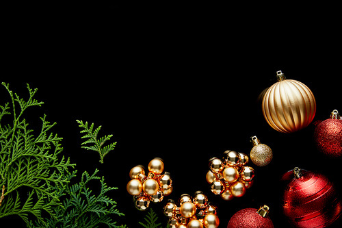 top view of shiny golden Christmas decoration, green thuja branches on blue background