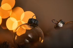 close up of transparent christmas balls with blurred yellow lights