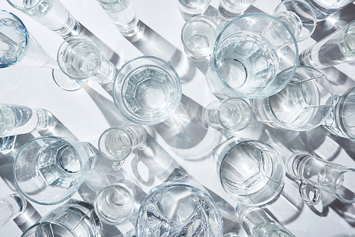 top view of transparent glasses with pure water on white background